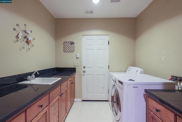 clothes washing area with sink, light tile patterned floors, cabinets, and independent washer and dryer