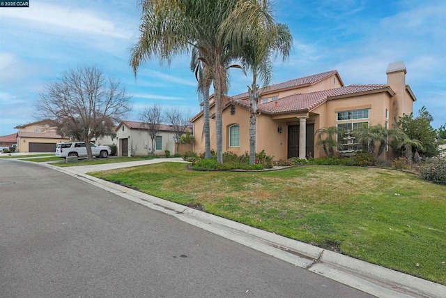 mediterranean / spanish-style home featuring a garage and a front lawn