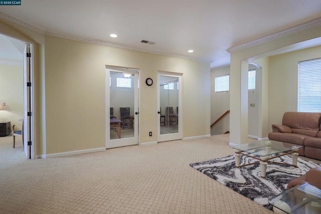 carpeted living room featuring a wealth of natural light, ornamental molding, and french doors