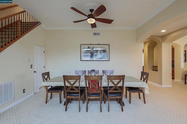 carpeted dining space with ornamental molding and ceiling fan