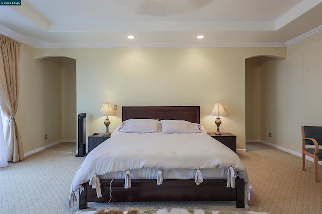 bedroom with a raised ceiling, ornamental molding, and light colored carpet