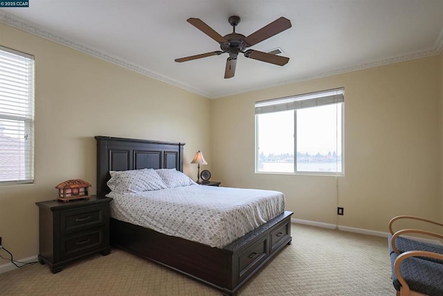 bedroom with multiple windows, crown molding, light carpet, and ceiling fan