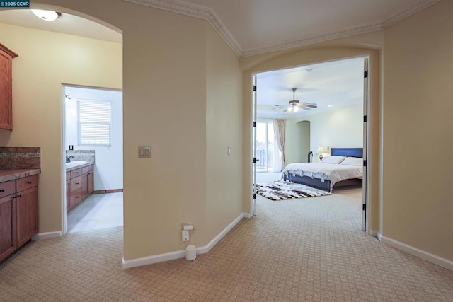 hall featuring light colored carpet, ornamental molding, and sink