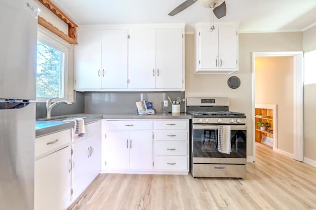 kitchen featuring sink, white cabinetry, light wood-type flooring, ceiling fan, and stainless steel appliances