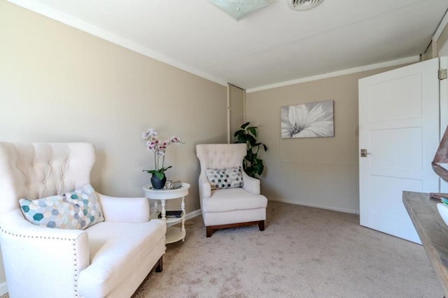 living area featuring crown molding and light carpet