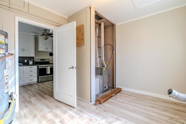 interior space with stainless steel range, gas water heater, light hardwood / wood-style floors, and ceiling fan