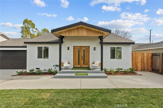 view of front of home featuring a garage, french doors, and a front lawn