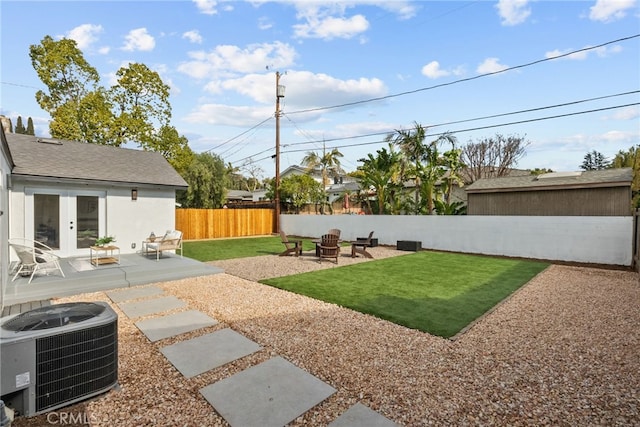 view of yard with a patio, central AC unit, a fire pit, and french doors