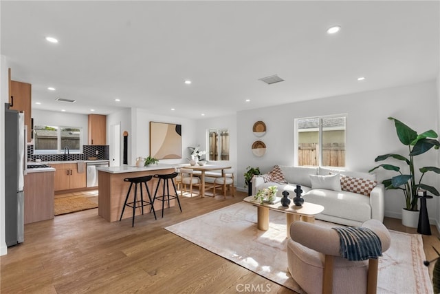 living room with sink and light hardwood / wood-style floors