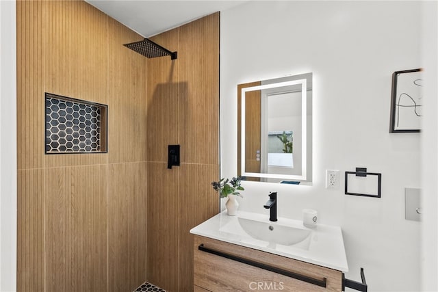 bathroom with vanity and a tile shower