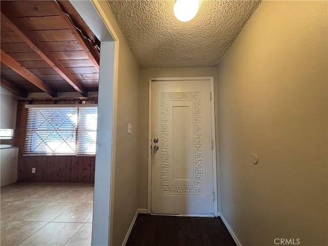 corridor with beam ceiling, wooden ceiling, and a textured ceiling