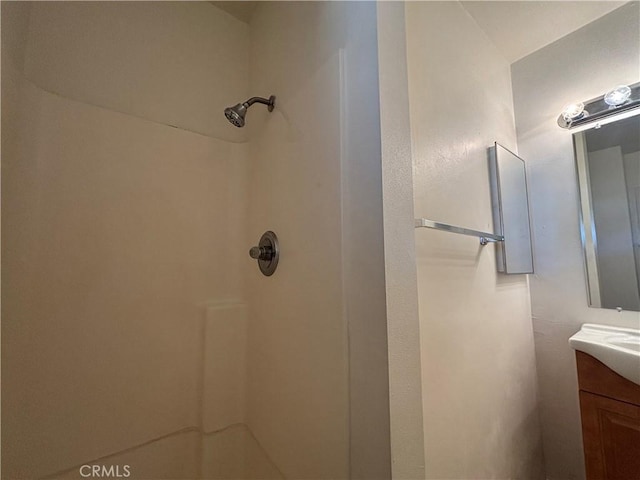 bathroom with walk in shower and vanity