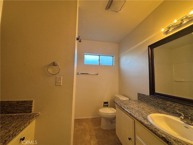 bathroom featuring vanity, tile patterned floors, and toilet