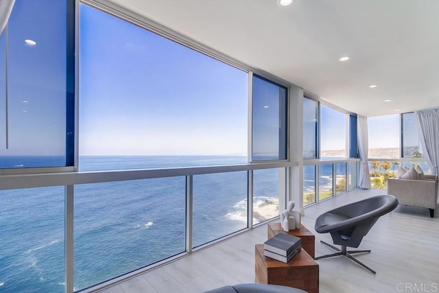 sunroom / solarium featuring a water view and a wealth of natural light