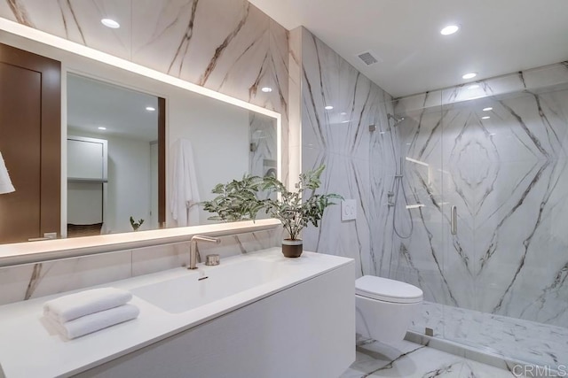 bathroom featuring vanity, tiled shower, and toilet