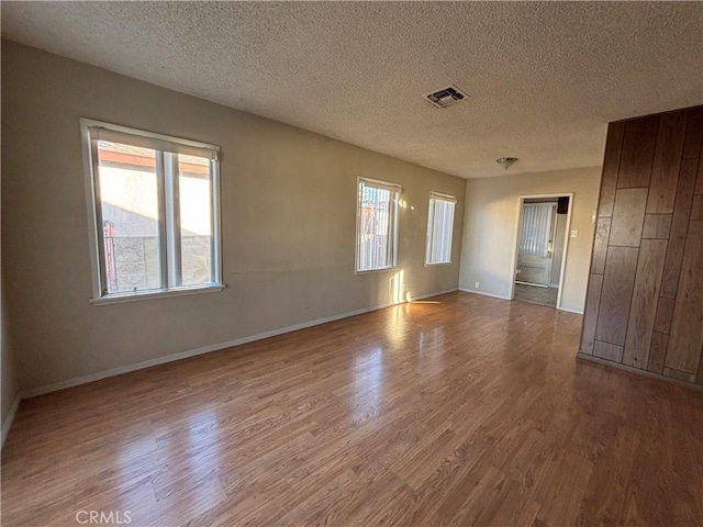 spare room with hardwood / wood-style floors and a textured ceiling