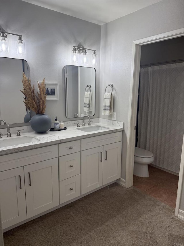 bathroom featuring vanity, tile patterned floors, and toilet