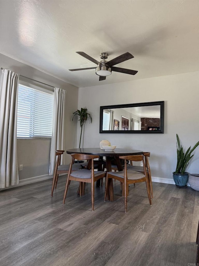 dining space with ceiling fan and dark hardwood / wood-style flooring