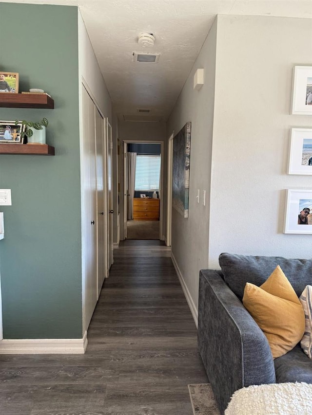 hall with dark hardwood / wood-style floors and a textured ceiling