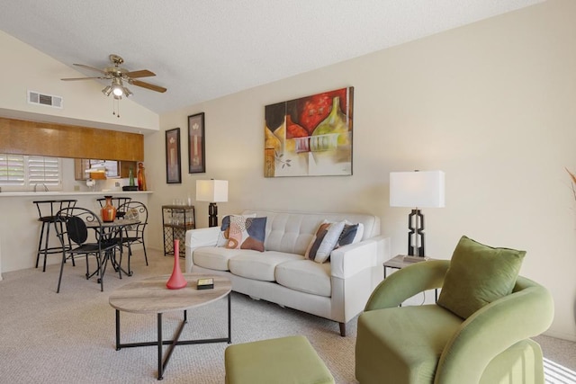 carpeted living room featuring vaulted ceiling and ceiling fan