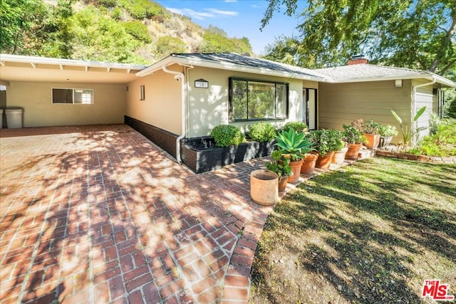 exterior space featuring a carport and a lawn