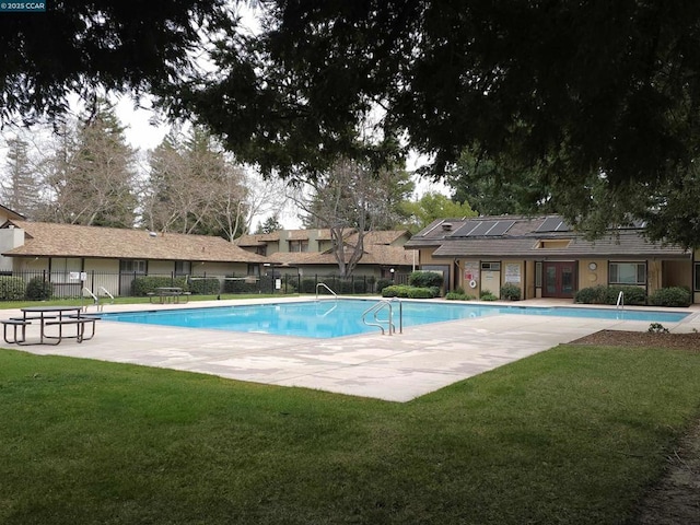 view of swimming pool featuring a lawn and a patio