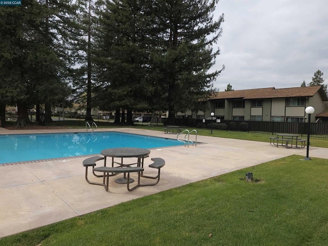 view of swimming pool with a patio and a lawn