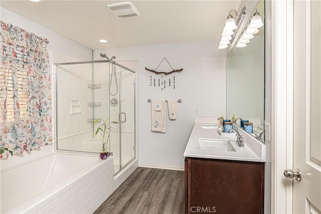 bathroom with plus walk in shower, wood-type flooring, and vanity