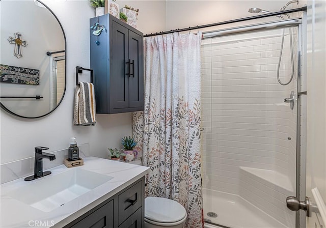 bathroom featuring vanity, curtained shower, and toilet