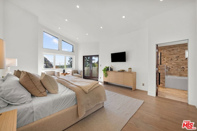 bedroom featuring light hardwood / wood-style flooring and a high ceiling