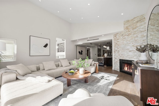 living room with hardwood / wood-style flooring, high vaulted ceiling, and a fireplace