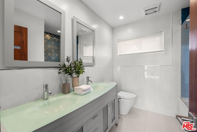 bathroom with tile walls, decorative backsplash, vanity, toilet, and tile patterned floors