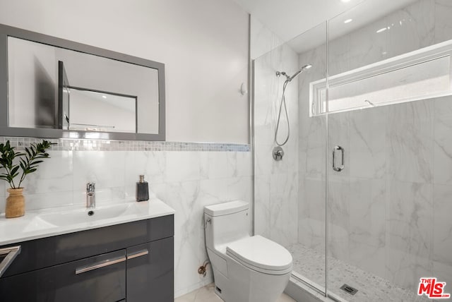 bathroom with walk in shower, vanity, toilet, and tile walls