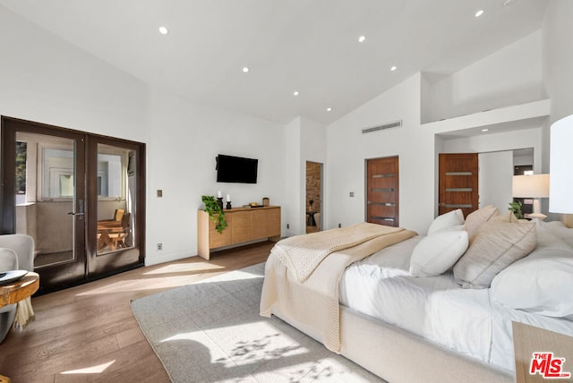 bedroom featuring french doors, high vaulted ceiling, and light wood-type flooring