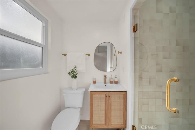 bathroom featuring vanity, toilet, and a shower with shower door