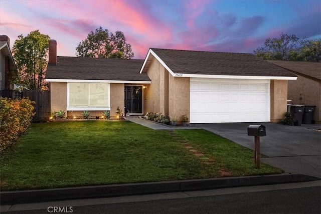 ranch-style house with a yard and a garage