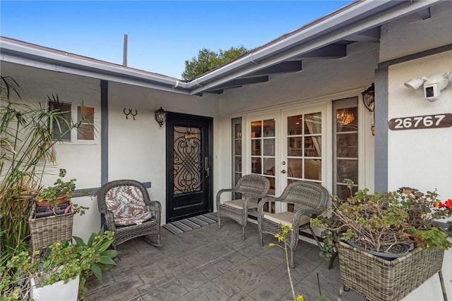 property entrance with a patio area and french doors