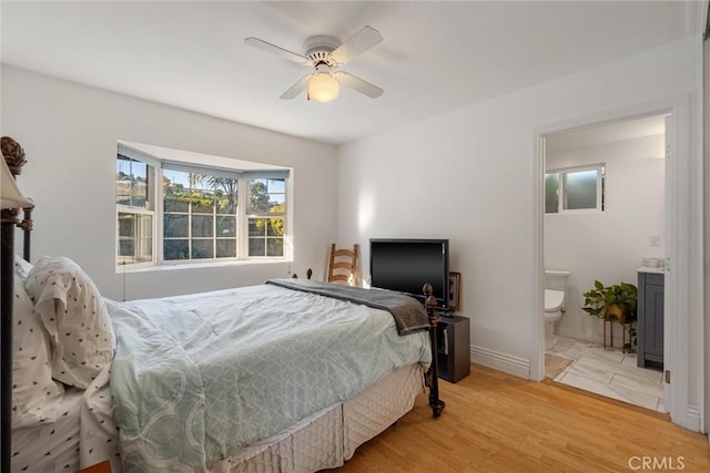 bedroom featuring light hardwood / wood-style flooring, ceiling fan, and ensuite bathroom