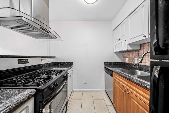 kitchen with sink, appliances with stainless steel finishes, dark stone countertops, tasteful backsplash, and white cabinets