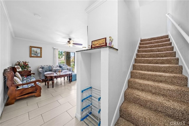 staircase featuring ornamental molding and ceiling fan