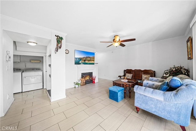 living room with ornamental molding, ceiling fan, and washer and clothes dryer