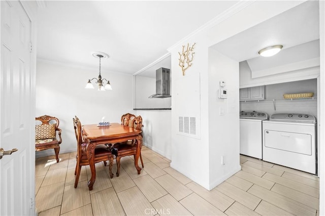 dining area with a chandelier, crown molding, and separate washer and dryer