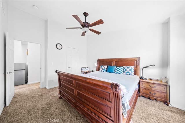 bedroom featuring stainless steel refrigerator, light colored carpet, and ceiling fan