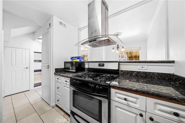 kitchen featuring white cabinetry, island exhaust hood, dark stone counters, and stainless steel gas stove