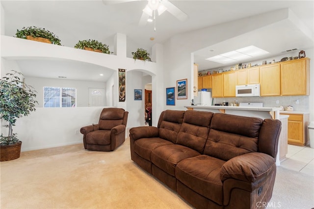 living room featuring lofted ceiling, light colored carpet, and ceiling fan