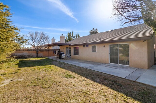 rear view of property featuring a yard and a patio