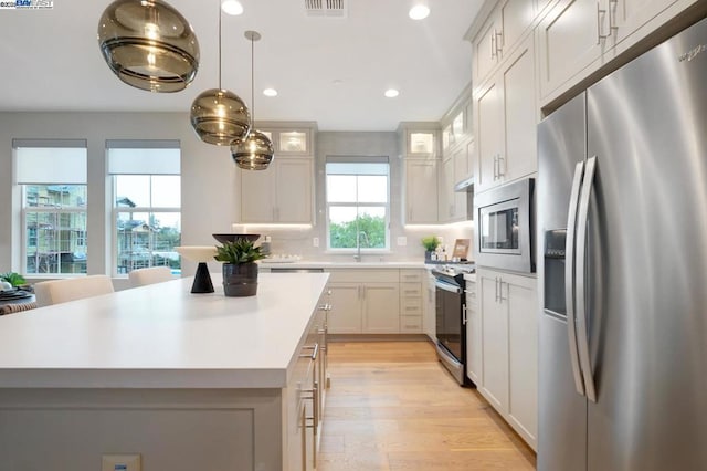 kitchen featuring a kitchen island, appliances with stainless steel finishes, and white cabinets