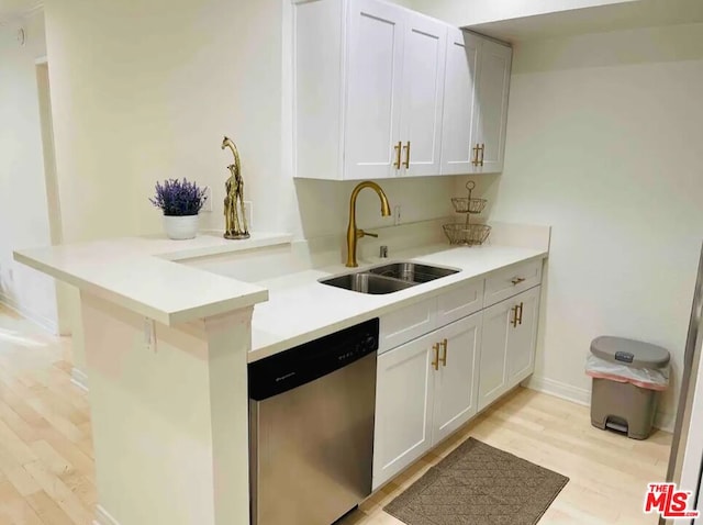 kitchen featuring sink, light hardwood / wood-style flooring, a breakfast bar area, white cabinetry, and stainless steel dishwasher