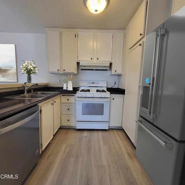 kitchen featuring stainless steel appliances, sink, white cabinets, and light hardwood / wood-style floors