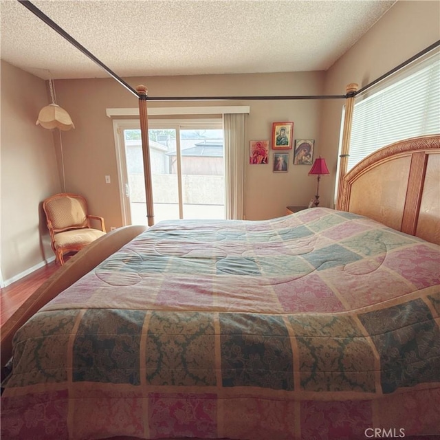 bedroom with hardwood / wood-style flooring and a textured ceiling